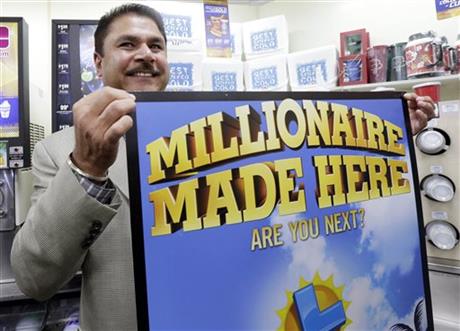 Balbir Atwal the owner of a 7 Eleven store that sold a winning Powerball lottery ticket holding up a Millionaire Made Here sign at his store in Chino Hills California