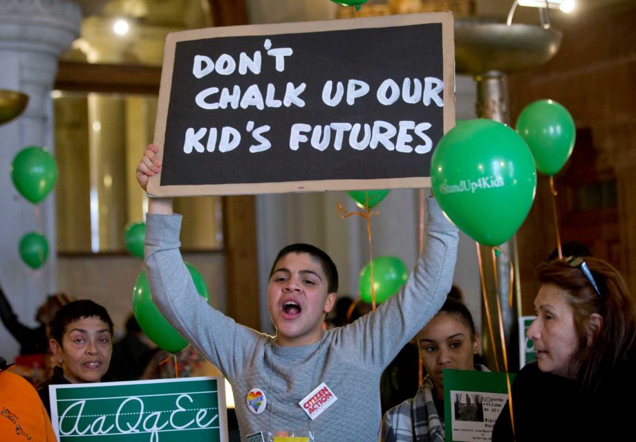 Juan Collado 15 of Rochester N.Y. holds a sign during a Stand Up for Kids education rally in the War Room at the Capitol Tuesday Jan. 12 2016 in Albany N.Y