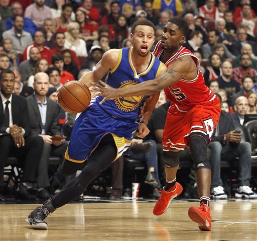 Golden State Warriors guard Stephen Curry left has the ball knocked out of his hand by Chicago Bulls guard E'Twaun Moore during the first half of an NBA basketball game Wednesday Jan. 20 2016 in Chicago