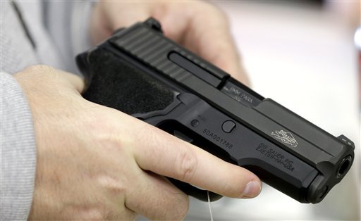 David Foley holds a handgun on Monday while shopping at the Spring Guns and Ammo store in Spring Texas. AP