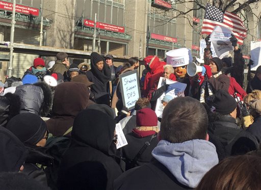 A group of over a hundred teachers joined by parents and children protest Monday Jan. 11 2016 in Detroit. A wave of teacher absences described by an activist as'rolling strikes shut down more than half of Detroit's 100 public schools Monday