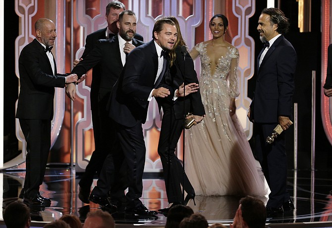 In this image released by NBC Leonardo DiCaprio center appears on stage with the cast and crew of'The Revenant' after the film won best motion