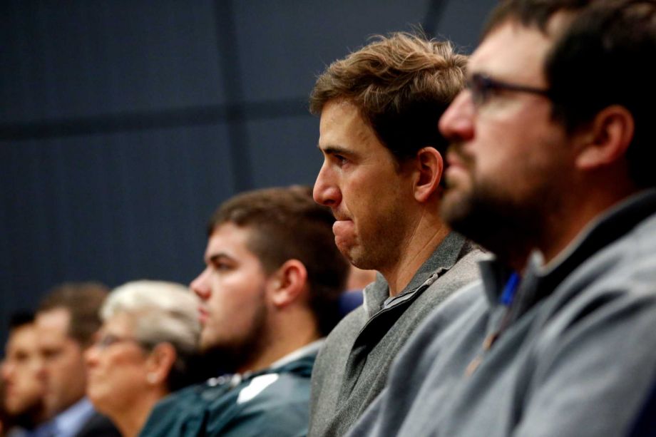 New York Giants quarterback Eli Manning center reacts while listening to former head coach Tom Coughlin speak during a news conference Tuesday Jan. 5 2016 in East Rutherford N.J. ORG XMIT NJJC107