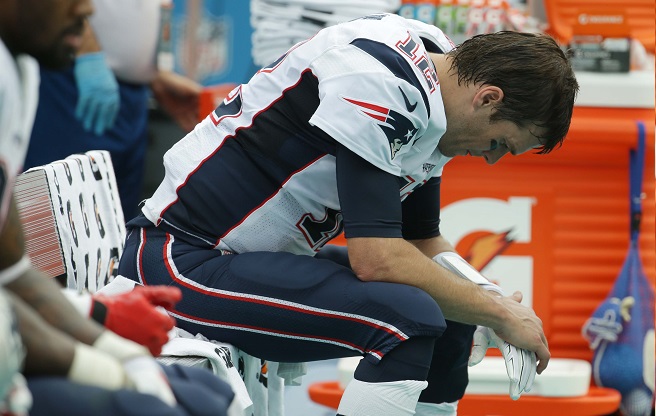 New England Patriots quarterback Tom Brady sits in the sidelines during the first half of an NFL football game against the Miami Dolphins Sunday Jan. 3 2016 in Miami Gardens Fla