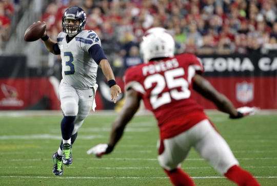 Seattle Seahawks quarterback Russell Wilson left prepares to throw as Arizona Cardinals cornerback Jerraud Powers looks on during the first half last Sunday in Glendale Ariz