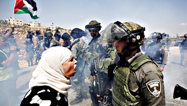 A Palestinian woman argues with an Israeli border policeman during a protest against Jewish settlements in the West Bank village of Nabi Saleh near Ramallah in October 2015