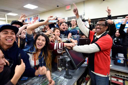 7-Eleven clerk M Faroqui celebrates with customers in Chino Hills after learning the store sold a winning Powerball ticket