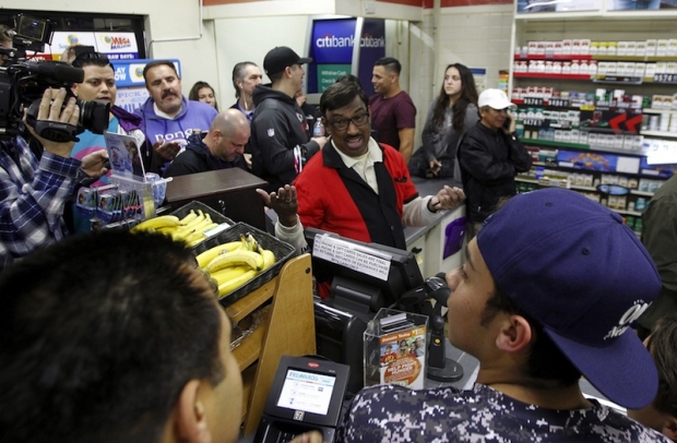 7-Eleven store clerk M. Faroqui celebrates after selling a winning Powerball ticket in Chino Hills California