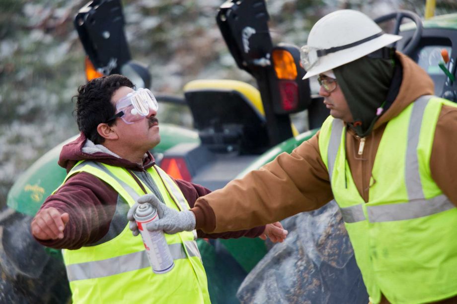 A worker is sprayed as part of the decontamination process Sunday at a farm in Dubois Ind. The number of birds ordered euthanized has exceeded 400,000