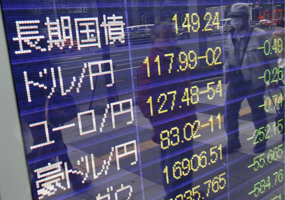 Pedestrians are reflected in an electronic board showing the exchange rates between the Japanese yen against the US dollar the euro and Australian dollar outside a brokerage in Tokyo Japan today. – Reuters pic January 7