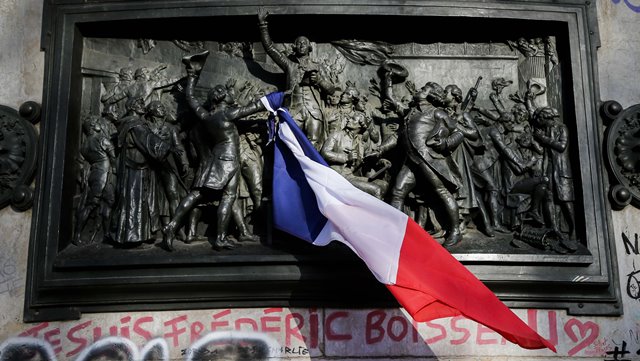 A French national flag is seen on the monument at the Place de la Republique square to mourn for the victims of the terrorist attacks in Paris capital of France Nov. 15 2015