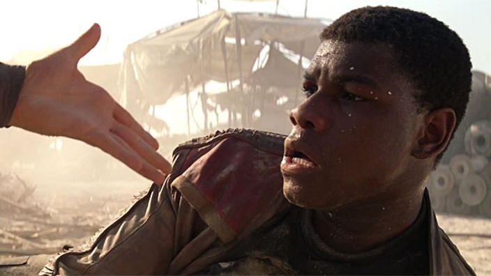 Finn the fallen stormtrooper gets a helping hand in Star Wars Episode VII The Force Awakens