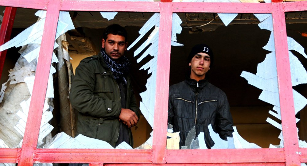 Afghan shopkeeper watches from the broken window of his shop near the site of suicide car bomb attack in Kabul Afghanistan