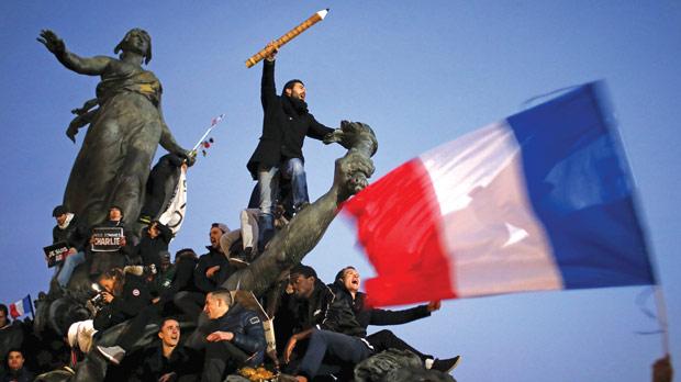 A man holding a giant pencil as he takes part in a solidarity march in the streets of Paris after the Charlie Hebdo shootings in January 2015