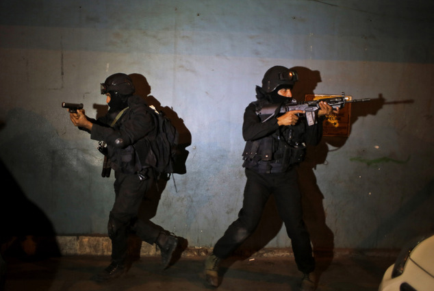 Commandos of National Security Group take positions during a mock terror attack drill ahead of Republic Day in New Delhi India Thursday Jan. 21 201