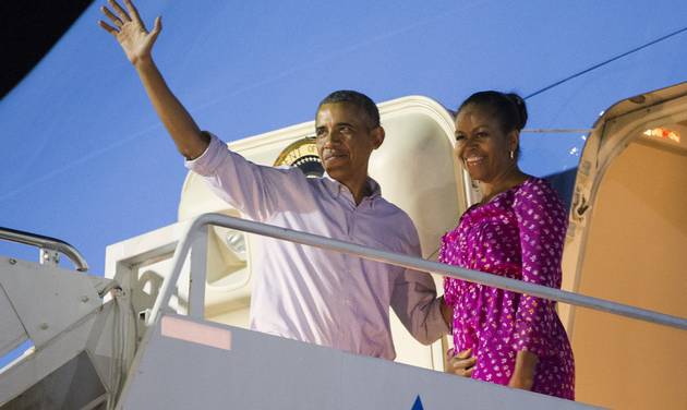 President Barack Obama left and first lady Michelle Obama wave as they board Air Force One to depart from Joint Base Pearl Harbor Hickam at the end of their family vacation on Saturday Jan. 2 2016 in Honolulu Hawaii