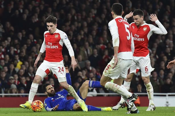 Cesc Fabregas falls in the area after a challenge from Arsenal's Laurent Koscielny