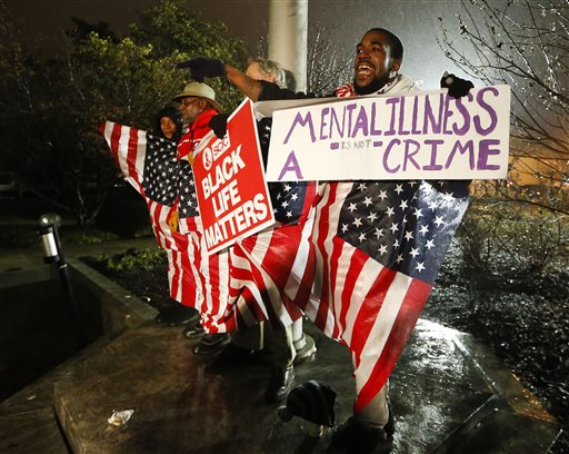 Protesters react outside the Dekalb County Ga. courthouse after it was announced that a grand jury decided to indict a Dekalb County police offer accused of shooting an unarmed naked man in March on Thursday Jan. 21 2016 in Decatur Ga. (AP