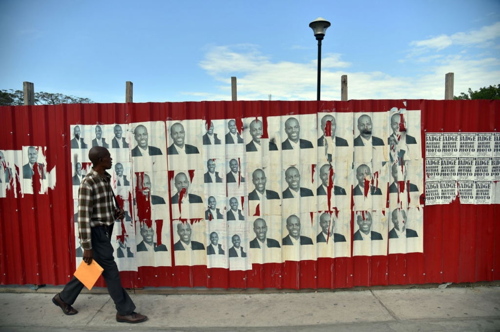 A man walks past election posters of presidential candidate Jovenel Moise of the PHTK political party in front of the National Palace in Port-au-Prince