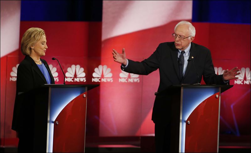 Democratic presidential candidate Sen. Bernie Sanders I-Vt answers a question as Democratic presidential candidate Hillary Clinton gestures during the NBC You Tube Democratic presidential debate at the Gaillard Center Sunday in Charleston S.C