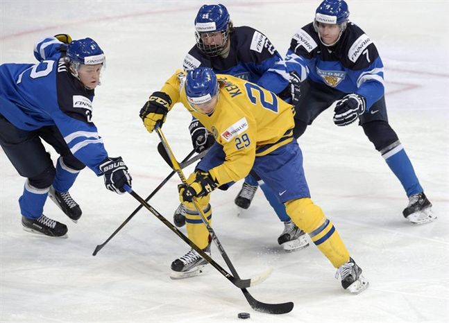 Sweden's Adrian Kempe center is surrounded by Finland's Sami Niku left Patrik Laine and Niko Mikkola right during the 2016 IIHF World Junior Ice Hockey Championship semifinal match between Sweden and Finland in Helsinki Monday Jan. 4 2016. (Marku