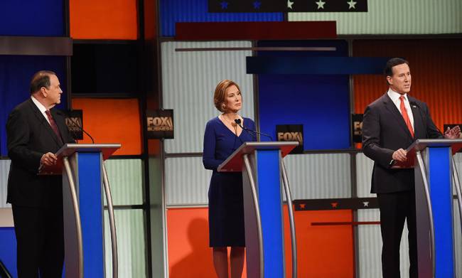 Republican presidential candidates from left former Arkansas Gov. Mike Huckabee former HP CEO Carly Fiorina and former Pennsylvania Sen. Rick Santorum take the stage before speak during the Fox Business Network Republican presidential debate at the No