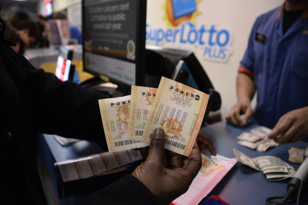 A customer shows their tickets for the Powerball lottery at the CA lotto store in San Bernardino County California on the California Nevada state line