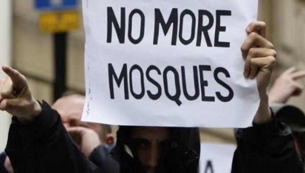 A supporter of the English Defence League holds an Islamophobic sign at a protest in the United Kingdom