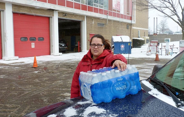 2016 Rabecka Cordell picks up a case of bottled water outside the fire station in Flint Mich. ¿We both have lead poisoning,¿ said C