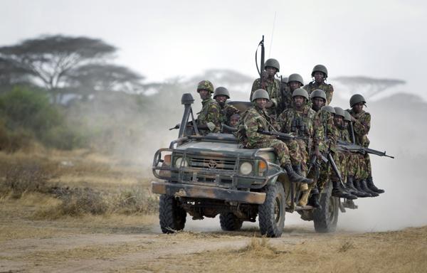 Kenyan soldiers ride on a vehicle at their base in Tabda inside Somalia