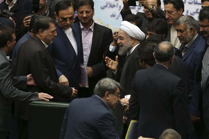 Iranian President Hassan Rouhani center gestures as he is greeted by lawmakers at the parliament to present draft of the country's next year budget and sixth development plan in Tehran Iran Sunday Jan. 17 2016. Rouhani said Sunday that the official