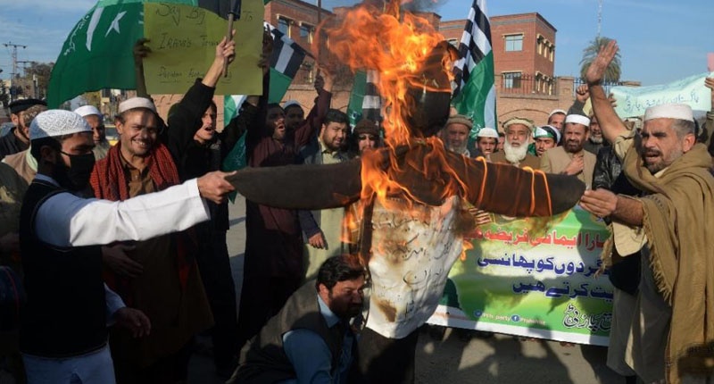 Pakistani activists of Rah e Haq Party burn an effigy to represent Iran and the United States during a protest in Peshawar