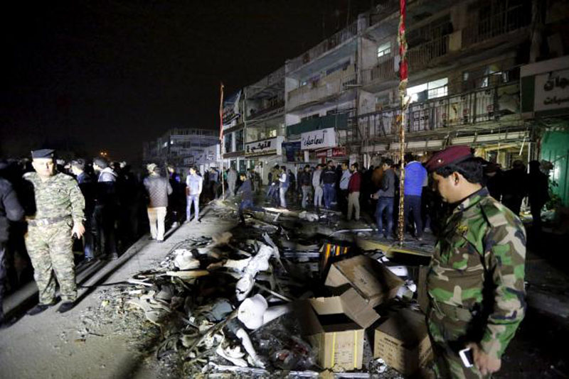 Iraqi security forces gather at the site of a car bomb in New Baghdad