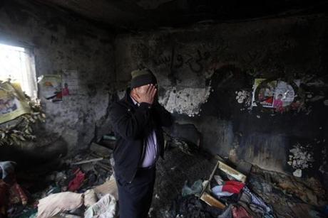 A relative reacted as he stood Sunday inside the burnt-out home of Saad Dawabsha who was killed alongside his toddler and his wife when their house was firebombed on July 31