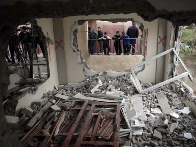 Palestinian boys look into the house of Bahaa Allyan who was shot dead after he and an accomplice reportedly boarded a bus and shot and stabbed people at a Jerusalem in October last year after it was partially demolished by Israeli forces in the east Je