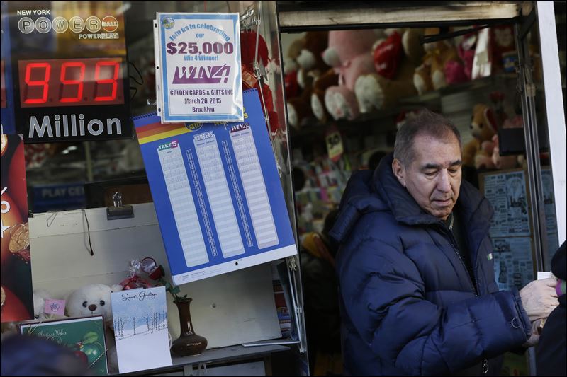 A sign advertising the Powerball lottery hangs on a store in New York. The jackpot is so big that billboards around the country have to advertise the prize as $999 million because they're not built to show billions