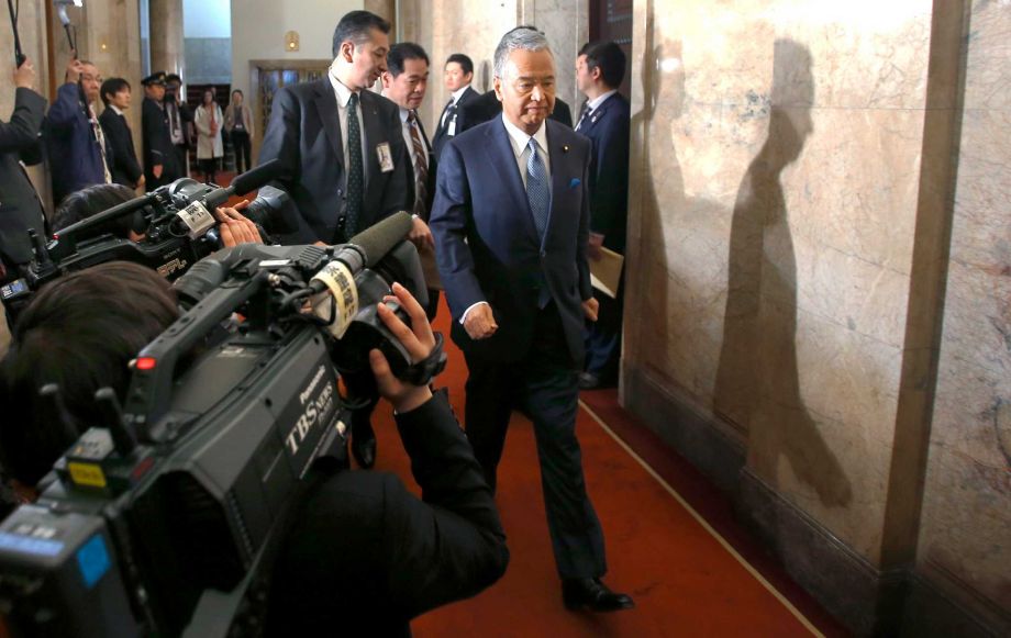 Japanese Economy Minister Akira Amari arrives at the upper house of the parliament in Tokyo Thursday Jan. 28 2016. Later Amari said he intends to resign due to allegations he accepted bribes from a construction company in a nationally televised news