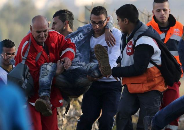 A wounded Palestinian protester is evacuated during clashes with Israeli troops near the West Bank city of Ramallah on Christmas Day