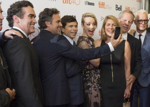 Actor Mark Ruffalo holds up a camera as cast member Rachel Mc Adams makes a funny face as they pose with the real life characters they portray as they arrive on the red carpet for the film'Spotlight during the 40th Toronto International Film Fes