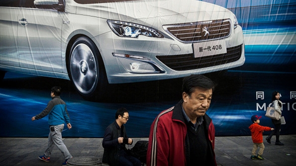 Chinese residents walk past an auto