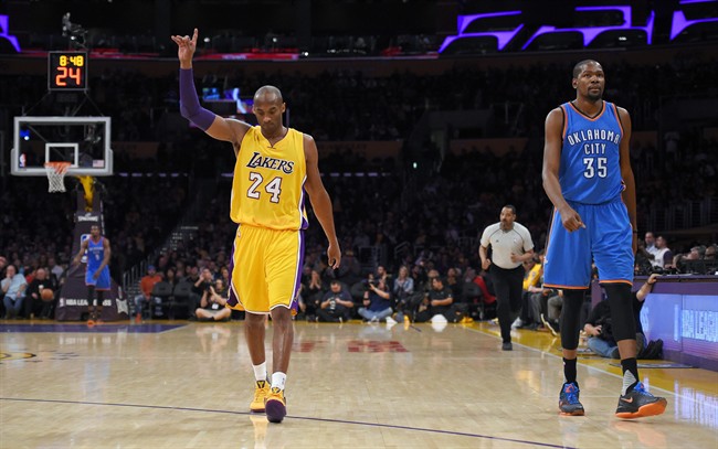 Los Angeles Lakers forward Kobe Bryant left gestures after scoring as Oklahoma City Thunder forward Kevin Durant walks next to him during the first half of an NBA basketball game Friday Jan. 8 2016 in Los Angeles