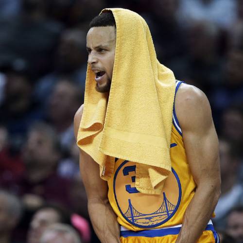 Warriors’ Stephen Curry cheers on his team from the bench in the first half of an NBA basketball game against the Cleveland Cavaliers Monday Jan. 18 2016 in Cleveland. The Warriors won 132-98