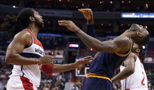 Cleveland Cavaliers forward Le Bron James right reacts after being hit in the face by Washington Wizards center Nene left from Brazil during the first