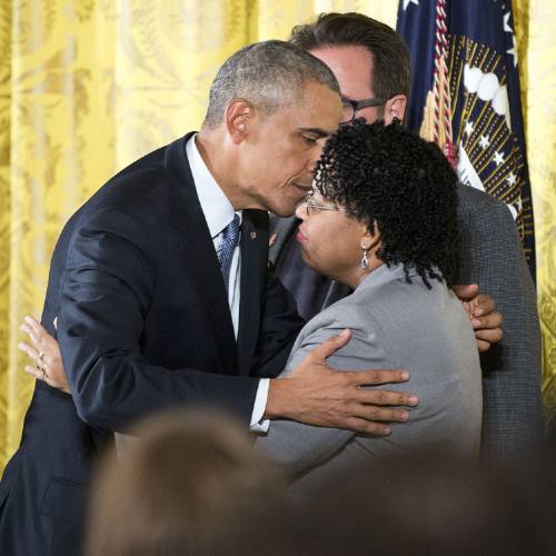 Obama embraces Jennifer Pinckney wife of Reverend Clementa Pinckney who was killed in the 2015 Charleston church shooting after speaking in the East Room of the White House in Washington Tuesday Jan. 5 2016 about steps his