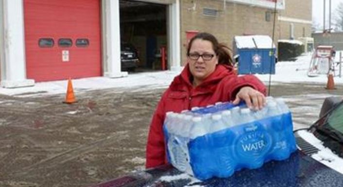 2016 Rabecka Cordell picks up a case of bottled water outside the fire station in Flint Mich. “We both have lead poisoning,” said Cordell who learned that two weeks ago from her doctor. She says she has leukemia and her son