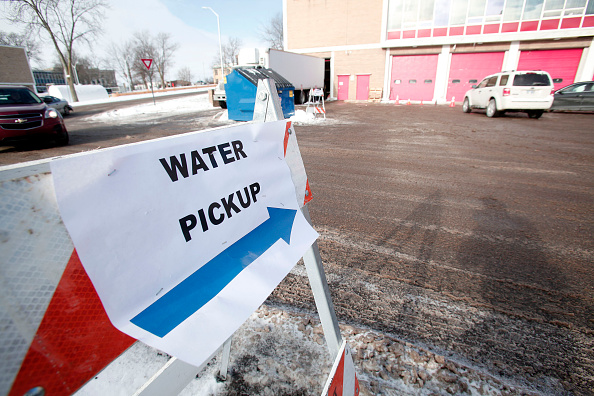 A sign points the ay for Flint residents to get bottled water water testing kits and water filters at a Flint Fire Stati