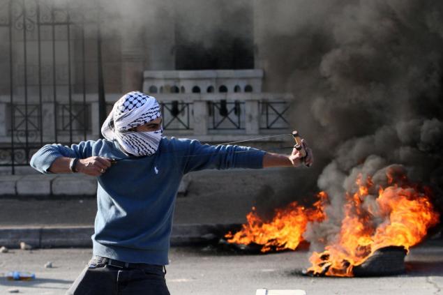 A Palestinian protester fires back David style in the Christmas Day clash with Israeli troops