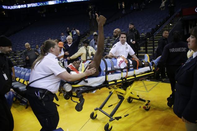 Kenneth Faried gives a thumbs up to those remaining as he is carted off the court on a stretcher