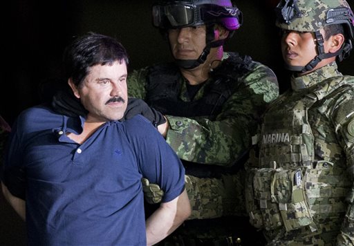 Joaquin'El Chapo Guzman is made to face the press as he is escorted to a helicopter in handcuffs by Mexican soldiers and marines at a federal hangar in Mexico City Mexico Friday Jan. 8 2016. Mexican President Enrique Pena Nieto announced that Guzman