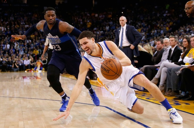 Klay Thompson of the Golden State Warriors slips while being guarded by Wesley Matthews of the Dallas Mavericks at ORACLE Arena in Oakland California on J